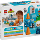 The LEGO® DUPLO® Blue Police Motorcycle by Legos - Toyhouse features a police officer on a DUPLO motorcycle, cones, and scenery. Perfect learning toy for toddlers ages 2 and up. Box shows a child playing in the background.