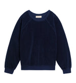 The Suzie Kondi Samos Sweatshirt is a navy blue long-sleeve crewneck with comfy sleeves, ribbed cuffs and hem, and a relaxed fit, shown flat on a white background—ideal for travel or lounging.