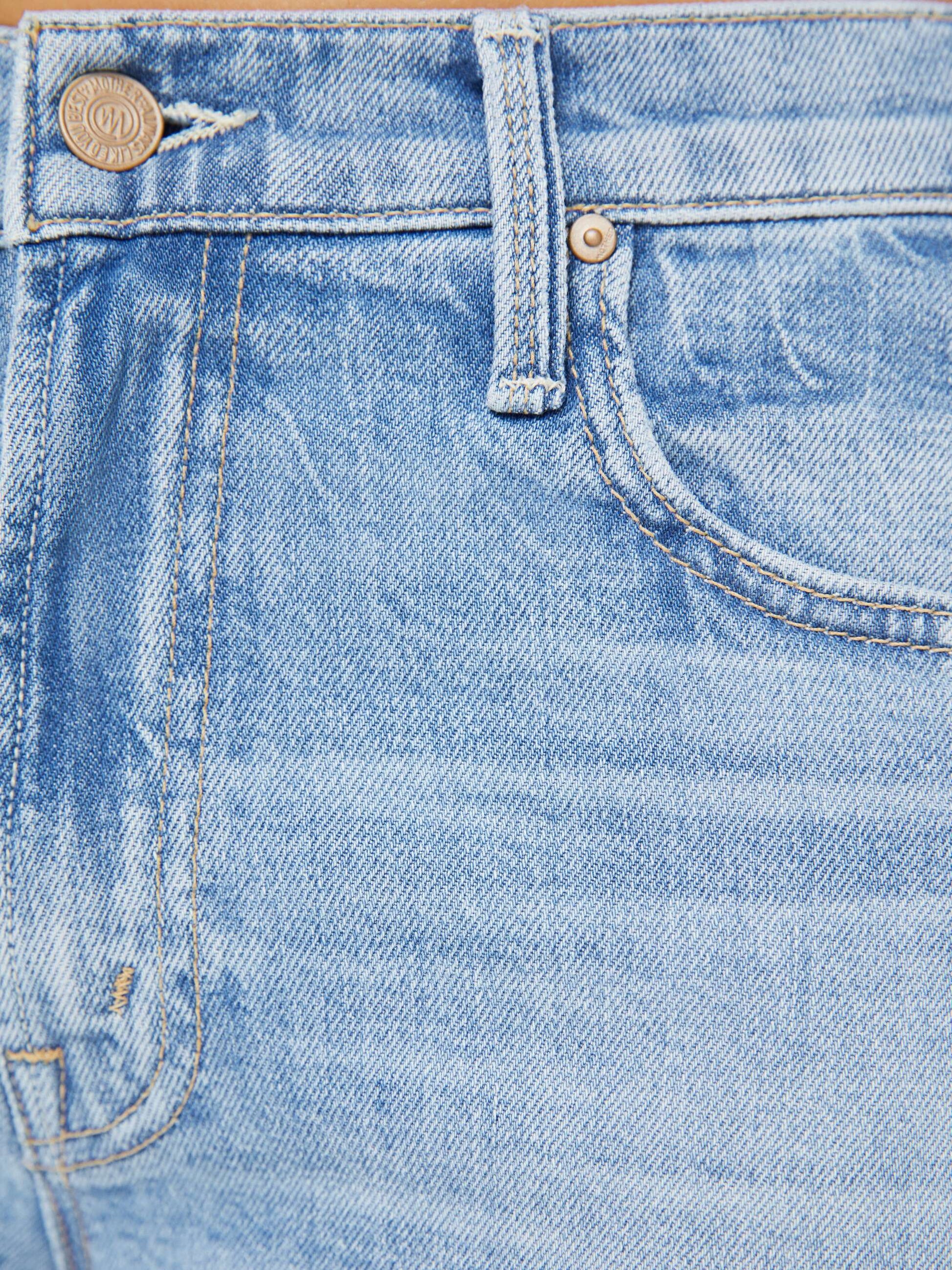 Close-up of the Mother Mid Rise Rambler Zip Ankle Fray jeans in light blue denim, featuring a waistband, front pocket, belt loop, metal button, and a subtle frayed ankle hem for a modern twist on classic wide straight leg style.