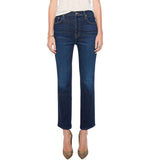 A person wears the Mother Tripper Flood dark blue, high-rise flare jeans crafted from a stretch cotton blend, paired with a light top and pointed-toe heels, standing against a white background.