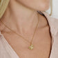 A woman wearing a pale pink blouse and the Anabel Aram Butterfly Gold Necklace, crafted in 18k gold and adorned with hand-set crystals.