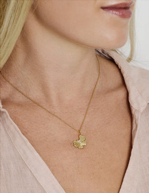 A woman wearing a pale pink blouse and the Anabel Aram Butterfly Gold Necklace, crafted in 18k gold and adorned with hand-set crystals.
