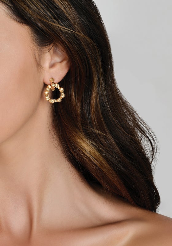 Anabel Aram Bamboo Double Hoop Earrings: small gold-plated brass hoops with a textured, segmented bamboo design worn in an earlobe.
