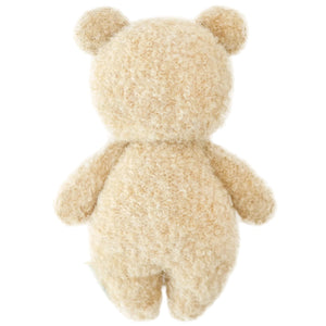 The Cuddle + Kind Baby Boucle Bear - Honey is shown from the back, highlighting its curly beige texture and soft Peruvian cotton yarn with visible head, ears, arms, and legs against a white background.