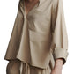 A person in a relaxed fit, TWP Day After Top by TWP, with an open collar and drawstring pants, stands with hands by their sides.