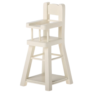 The Maileg High Chair - Micro is a small, white wooden chair with a backrest, armrests, and footrest—perfectly sized for micro bunnies or other Micro-sized Maileg friends.