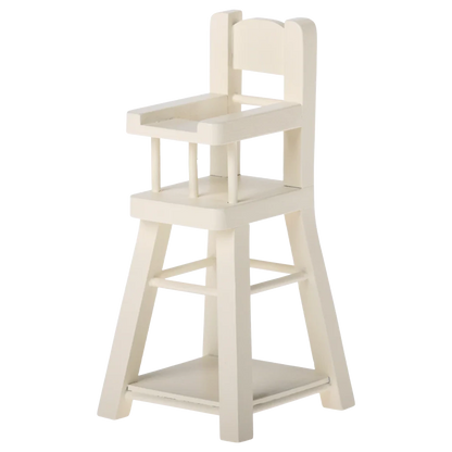 The Maileg High Chair - Micro is a small, white wooden chair with a backrest, armrests, and footrest—perfectly sized for micro bunnies or other Micro-sized Maileg friends.