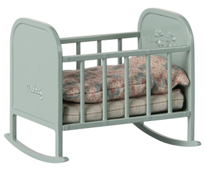 The Maileg Cradle, My - Blue Mint is a small cradle featuring blue mint colors, floral-patterned bedding, a cozy mattress, and a pillow inside.