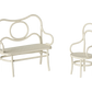 The Maileg Cafe Set, Mouse, Small - Off White bench and chair feature artistic circular and curved metal designs with woven seats, evoking the charm of a mice café.