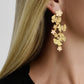 Close-up of a woman wearing Anabel Aram’s Butterfly with Flowers Dangle Earrings, featuring elegant butterfly and floral motifs.
