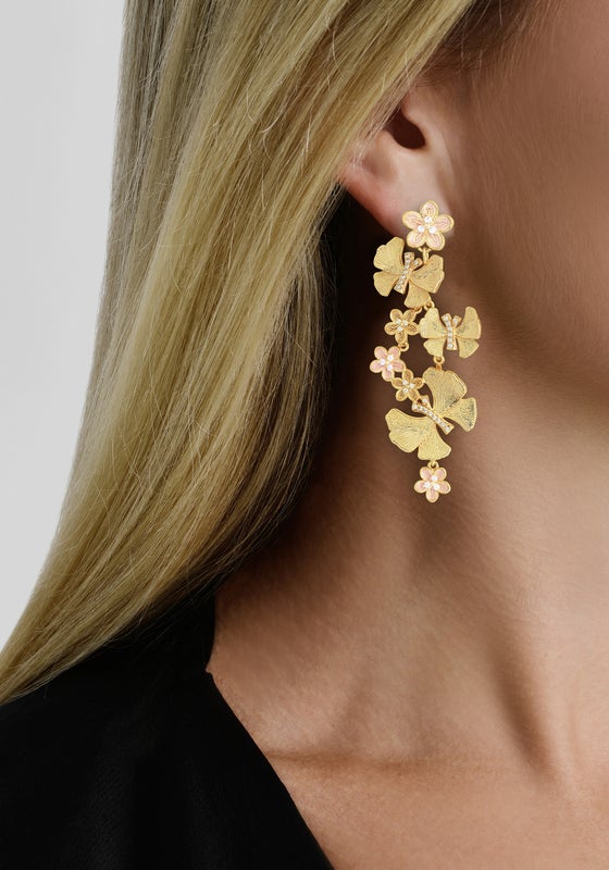 Close-up of a woman wearing Anabel Aram’s Butterfly with Flowers Dangle Earrings, featuring elegant butterfly and floral motifs.