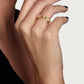 A close-up of a hand with black nail polish wearing the Anabel Aram Bamboo Single Ring, an elegant 18k gold design, held near the chin against a plain background.