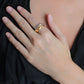 A person in a black top rests their hand on their chest, displaying the Anabel Aram Farrier Mixed Metal Triple Band Ring with a subtle hammered texture on their middle finger.