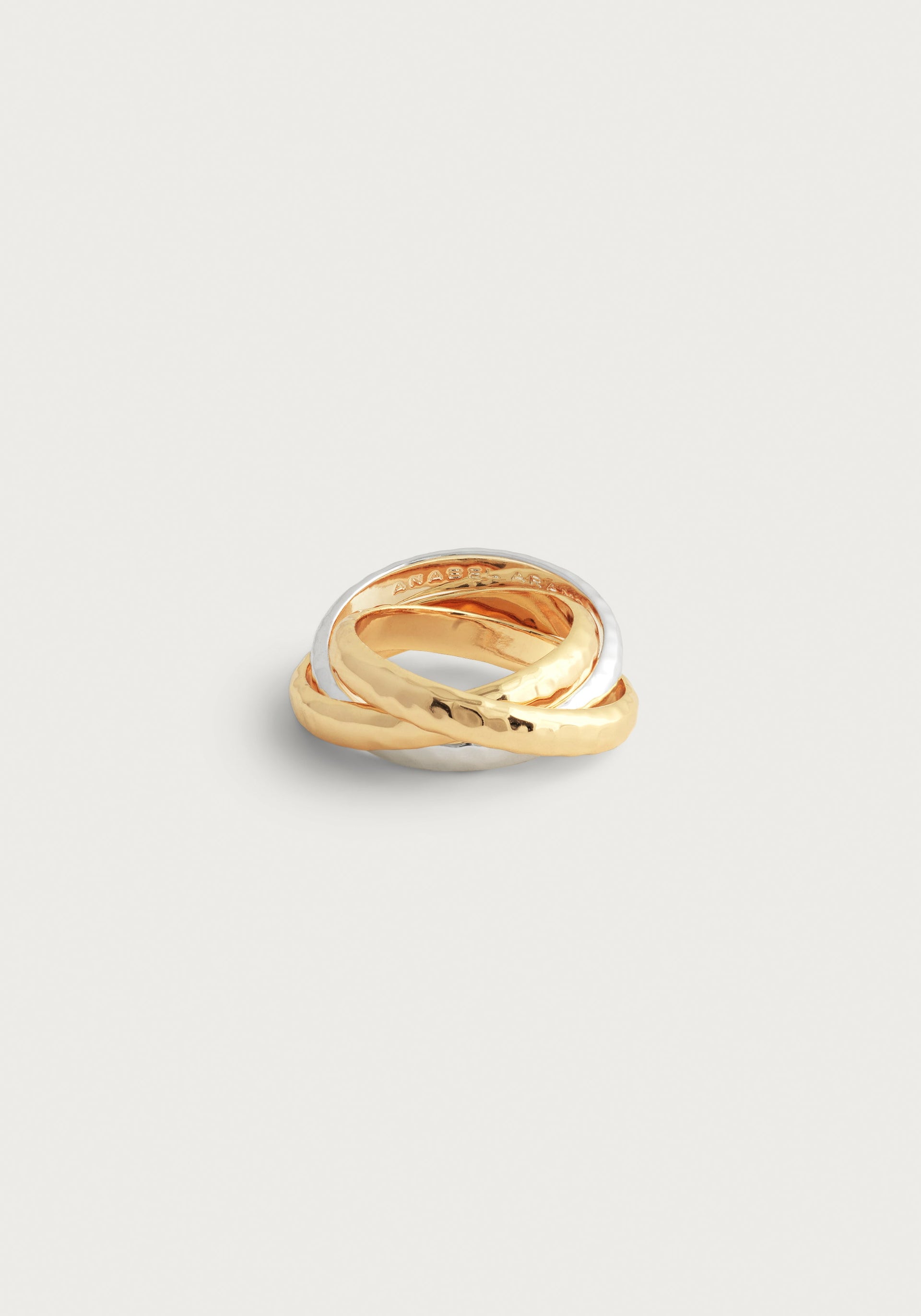 The Anabel Aram Farrier Mixed Metal Triple Band Ring features interlocking gold, silver, and rose gold bands with a hammered texture, creating standout jewelry when displayed on a white background.
