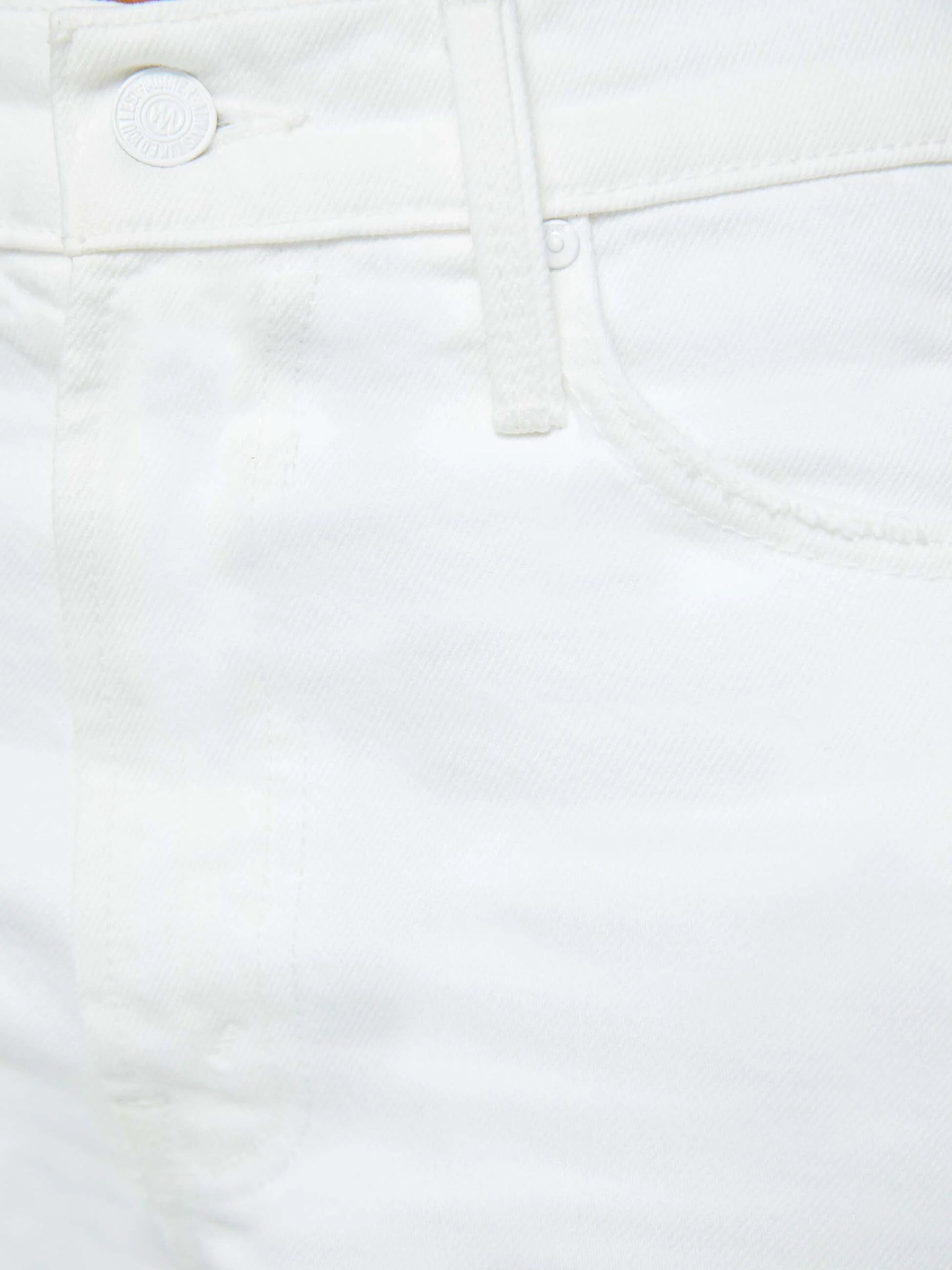 Close-up of the front pocket and waistband on Mother’s The Ditcher Roller Zip Ankle jeans, highlighting the button, belt loop, and seam details on these 70s-inspired white cotton jeans.