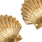 Close-up of Jennifer Behr's Mar Earrings—two golden, scallop shell-shaped pieces, handmade in New York and arranged diagonally on a white background.