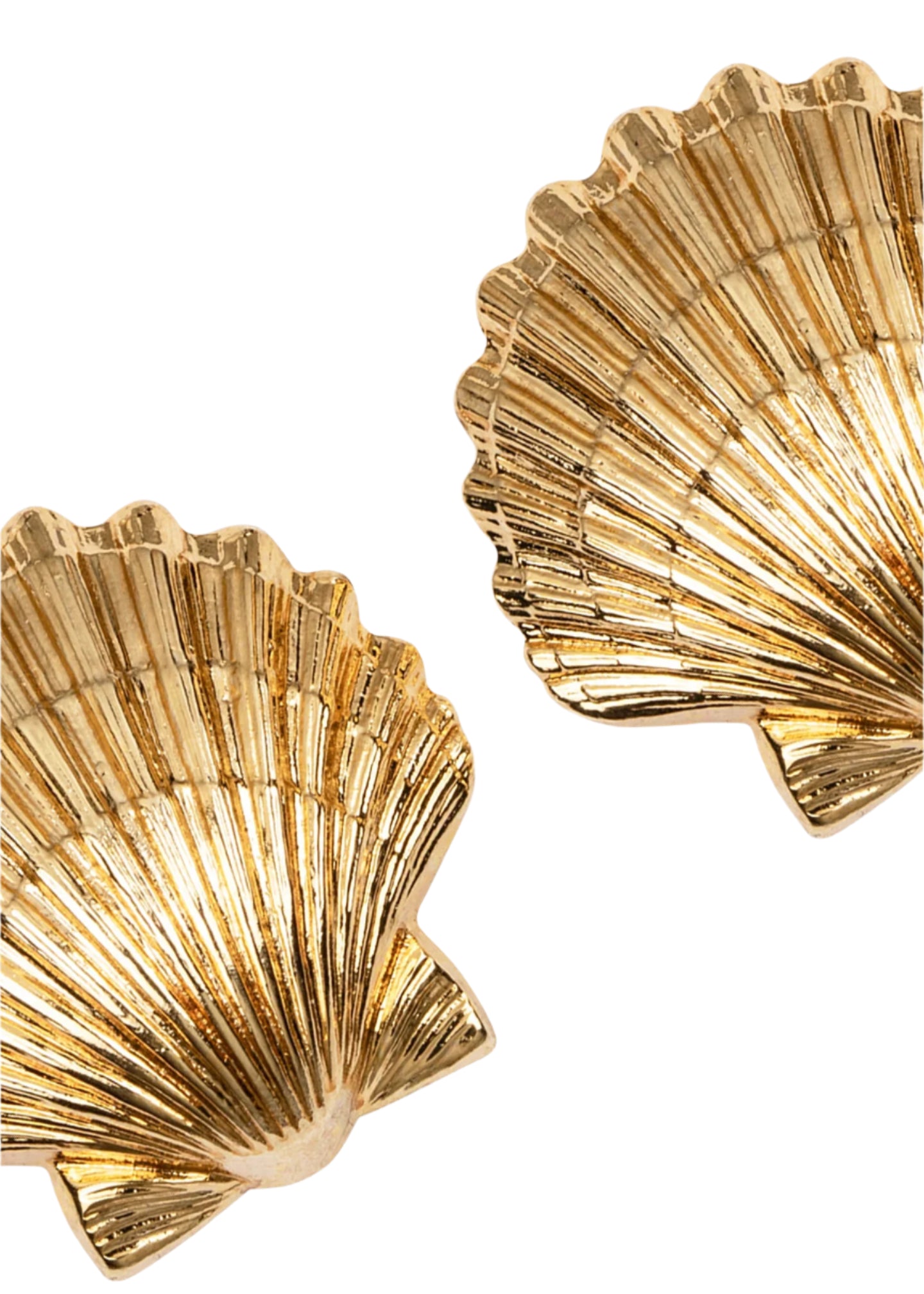 Close-up of Jennifer Behr's Mar Earrings—two golden, scallop shell-shaped pieces, handmade in New York and arranged diagonally on a white background.
