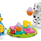 Two toy figures—Bluey and Chloe—gather around a colorful table with cupcakes, mugs, and a green leaf in the LEGO® Playground Fun with Bluey and Chloe set by Legos - Toyhouse, perfect for preschool play.