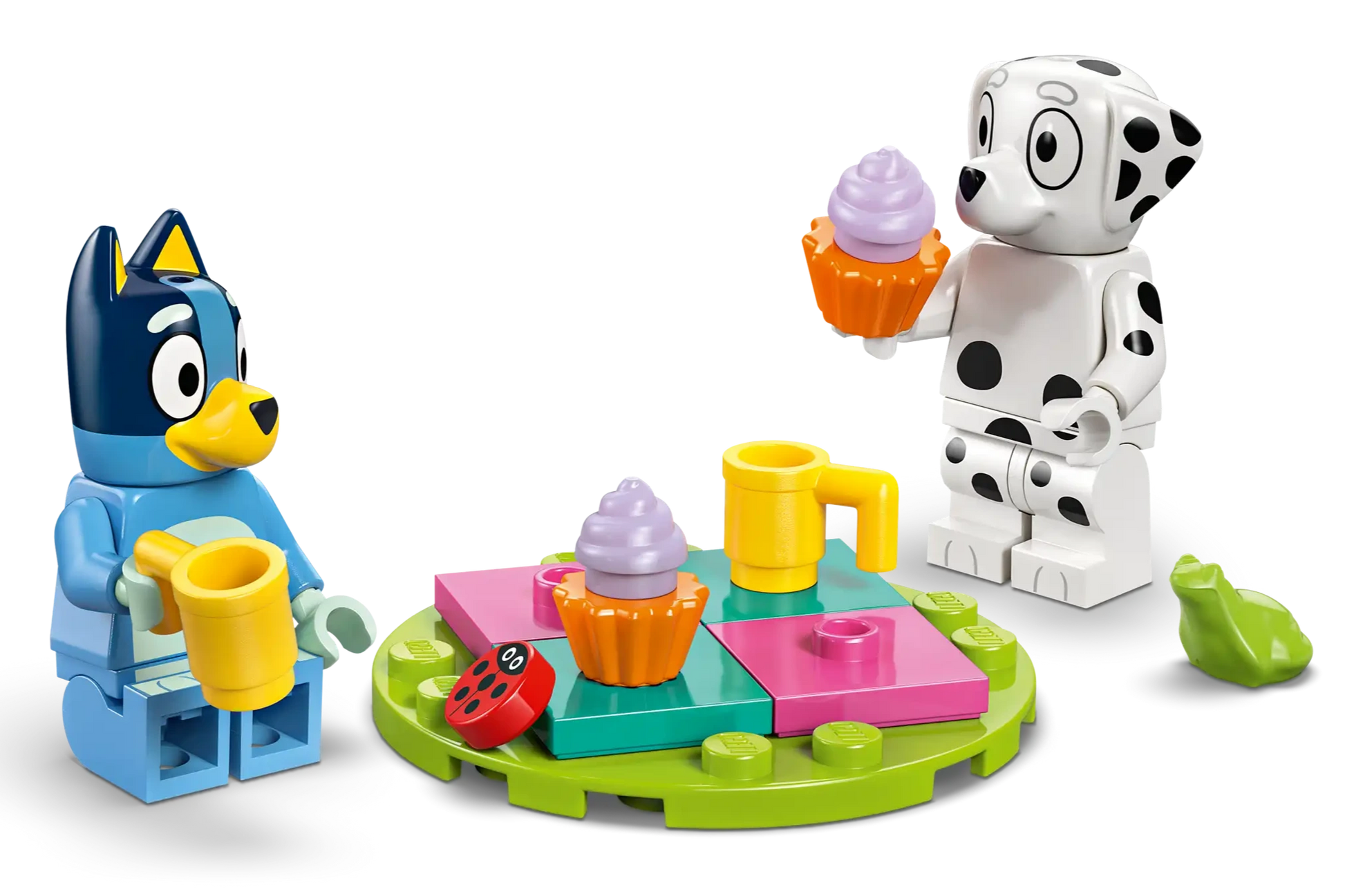 Two toy figures—Bluey and Chloe—gather around a colorful table with cupcakes, mugs, and a green leaf in the LEGO® Playground Fun with Bluey and Chloe set by Legos - Toyhouse, perfect for preschool play.
