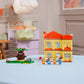 The LEGO® Bluey's Family House set by Legos - Toyhouse is displayed on a light blue round table in a colorful, decorated room.