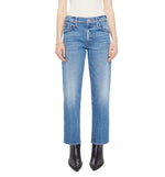 A person wearing Mother’s The Newbie Ankle mid-rise straight-leg blue jeans in rigid denim, a white top, and black pointed-toe boots, stands against a plain white background.