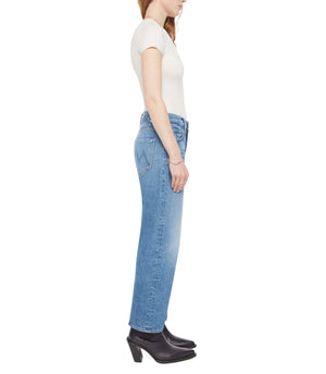 A woman is shown in profile wearing Mother’s The Newbie Ankle light blue mid-rise straight-leg jeans, a white short-sleeve top, and black heeled boots against a white background.