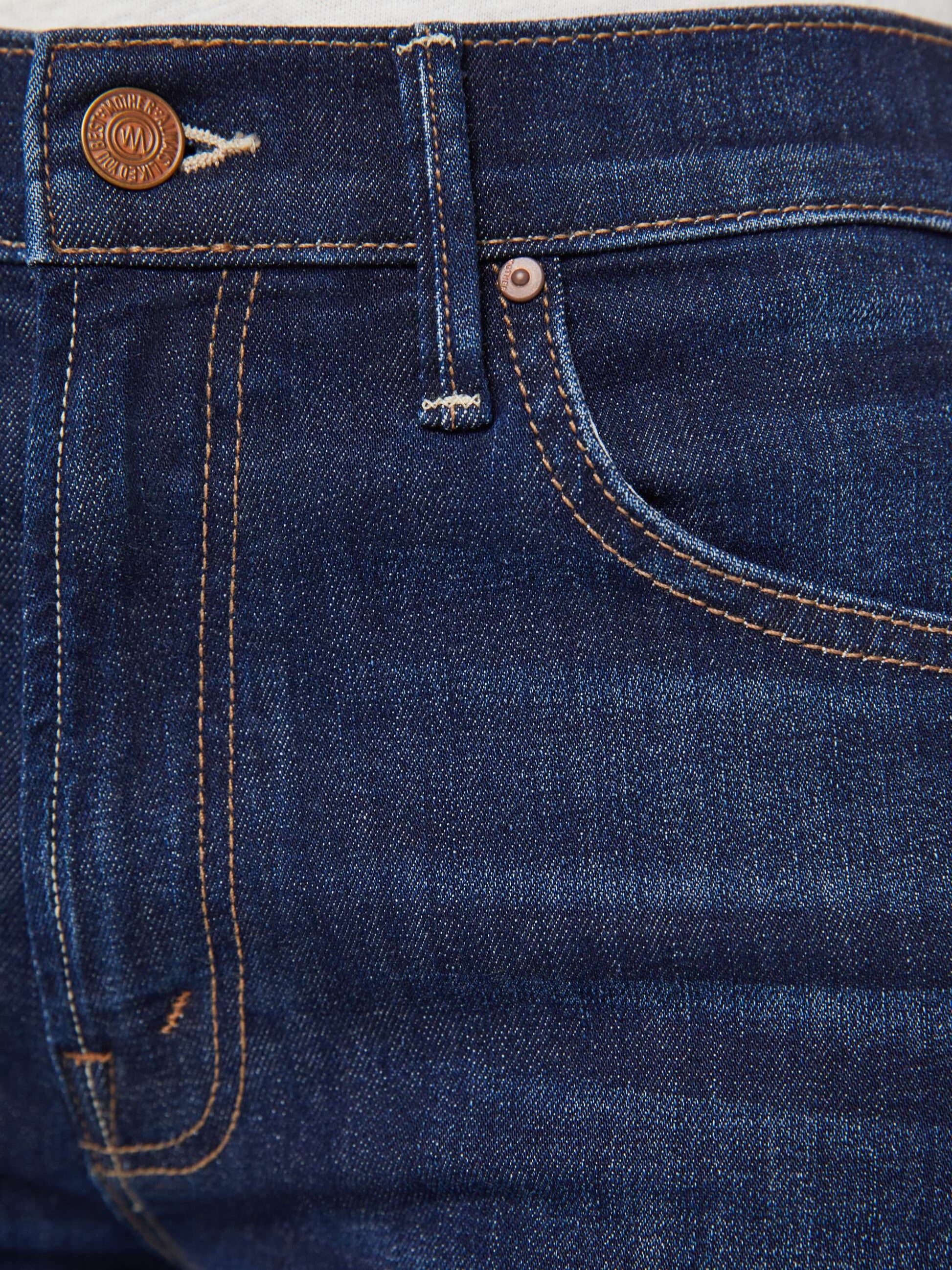 Close-up of the front pocket and waistband on Mother’s The Insider Crop Step Fray high-waisted bootcut jeans in blue denim, featuring visible stitching and a metal button.