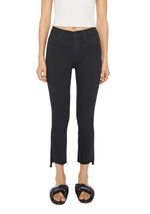 A person wearing a white crop top, black The Insider Crop Step Fray jeans by Mother, and black slide sandals stands against a plain white background.