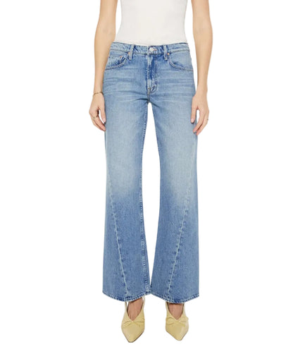 Model wearing "The Bookie Twist Skimp" high-waisted, wide-leg jeans in light blue by Mother, styled with beige pointed shoes; photographed from waist to feet against a white background.