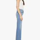 A woman stands in profile against a plain white background wearing a white tank top paired with Mother’s The Bookie Twist Skimp high-waisted light blue superior denim jeans and beige pointed-toe shoes.