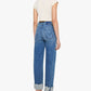 A person stands with their back to the camera, wearing a short-sleeve white top and the Half Pipe Flood Cuff Fray high-waisted, wide-leg jeans by Mother, crafted from SUPERIOR denim with cuffed hems, paired with black heeled sandals.