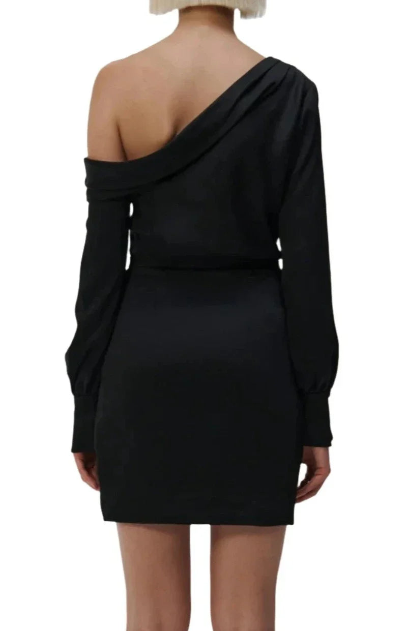 Back view of a person wearing a black Simkhai Cameron One Shoulder Mini Dress with long sleeves, standing against a plain white background.