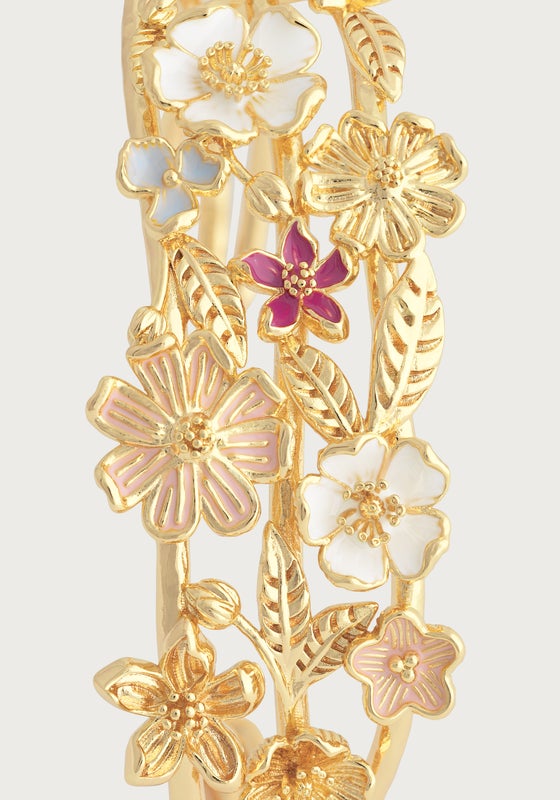 Close-up of the Anabel Aram Wildflowers Bangle, crafted in 18k gold and detailed with gold leaves and multicolored, hand-painted enamel flowers in white, pink, and purple.