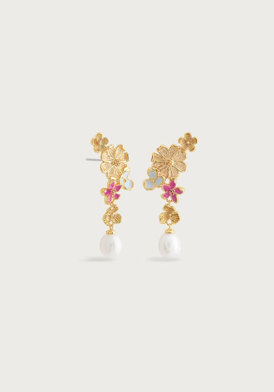 The Wildflowers Pearl Drop Earrings by Anabel Aram feature gold floral designs with pink, blue, and white accents and a dangling white pearl. These 18k gold-dipped earrings are a stunning piece of handcrafted jewelry.
