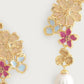 Close-up of Anabel Aram’s Wildflowers Pearl Drop Earrings: 18k gold-dipped, with pink and blue enamel flowers and a single dangling white pearl.