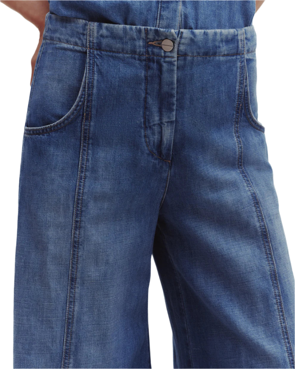 Close-up of the Dancing In The Dark Jeans by TWP featuring a relaxed fit, ultra-wide legs, front pockets, and a button closure in blue denim.