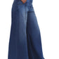 Wearing TWP's Dancing In The Dark Jeans, someone effortlessly styles the ultra wide leg lightweight denim with a hand in the pocket and pairs them perfectly with pointed-toe shoes.