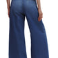 A person is seen from the back wearing the TWP Dancing In The Dark Jeans, which are relaxed fit, wide-leg blue denim pants, paired with a matching denim shirt.