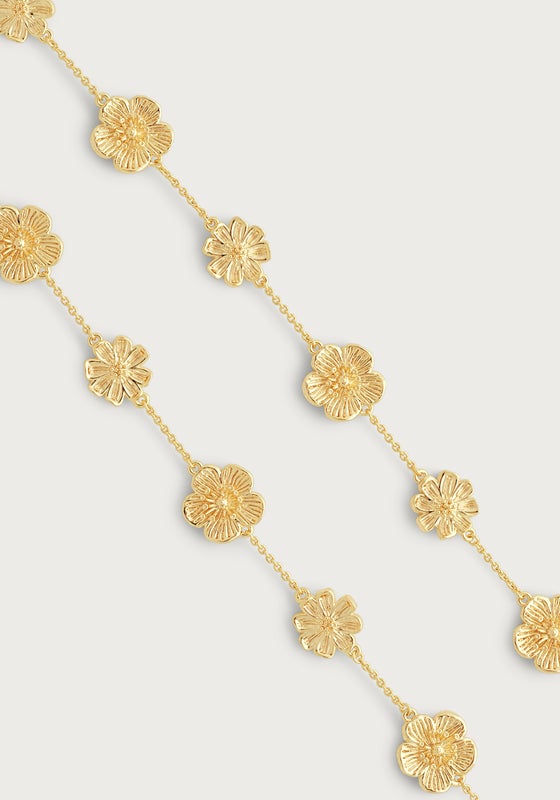The Anabel Aram Wildflowers Station Necklace features gold-dipped, textured flower charms evenly spaced in a repeating pattern—a beautiful, nature-inspired jewelry piece.