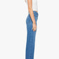 A woman stands in profile against a plain white background, wearing a white sleeveless top, black shoes, and blue Mother Mid Rise Lasso Sneak denim wide-leg pants.