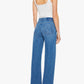 A person stands facing away, wearing a white tank top, the Mid Rise Lasso Sneak high-waisted wide-leg jeans by Mother crafted from SUPERIOR denim, black sandals, and a bracelet, against a plain white background.