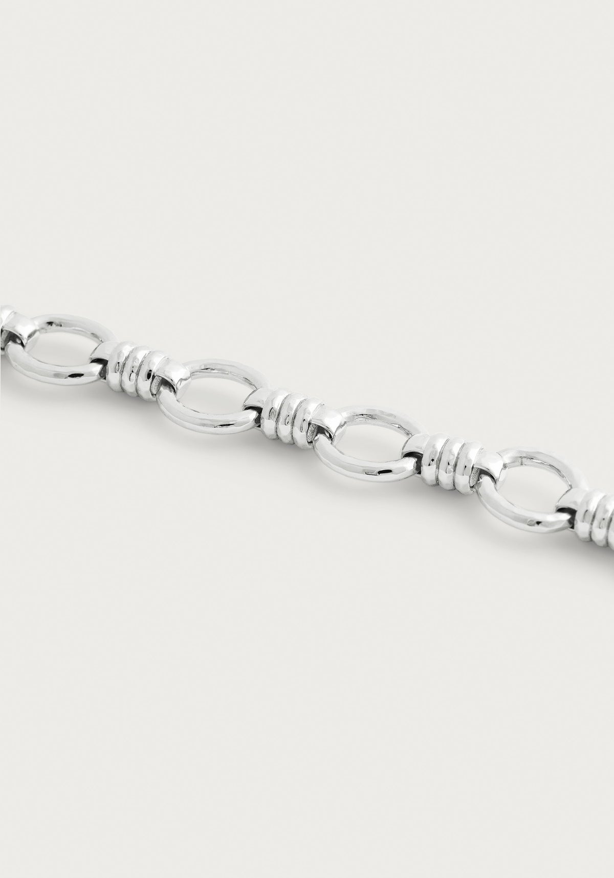 Anabel Aram Neptune Chain Bracelet in silver, featuring repeating oval links separated by ribbed cylindrical connectors.