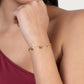 An 18k gold plated Heart Station Bracelet featuring small, evenly spaced heart-shaped charms, worn on a person’s wrist.