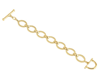 The Anabel Aram Cheval Chain Bracelet features gold-plated oval links with textured detailing, a T-bar clasp, and a D-shaped toggle closure, shown against a white background.