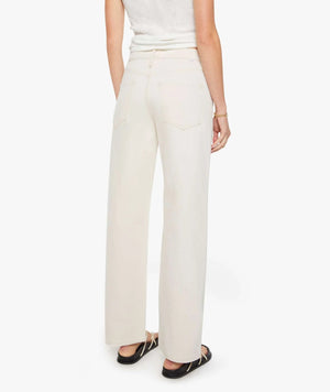 A person stands facing away wearing the Dodger Skimp high-waisted, loose straight leg pants in SUPERIOR cotton by Mother and a sleeveless top.