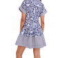A person stands with their back to the camera against a plain background, wearing the Cara Cara Nash Mini Dress—a short, blue and white fit-and-flare style featuring short sleeves and side seam pockets.