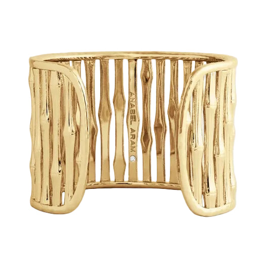 The Bamboo Wide Cuff by Anabel Aram is a wide gold bracelet with a bamboo-inspired design, bringing an equestrian elegance and featuring "Anabel Aram" engraved on the inside.