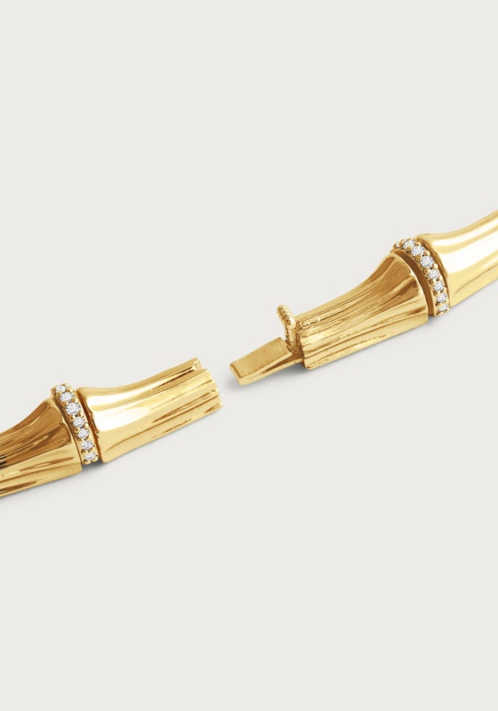 Close-up of the Anabel Aram Bamboo Necklace, crafted from 18k gold dipped brass with textured links and crystal-studded bamboo details, shown open at the clasp against a plain, light background.
