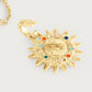 The Milos Soleil Charm by Anabel Aram is a gold sunburst necklace with a textured, sun-shaped pendant featuring colorful round stones and an attached chain, inspired by Mediterranean sun jewelry.