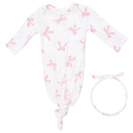 The Angel Dear Baby Girls’ Knotted Gown and Knot Headband set features a white modal gown with long sleeves, a pink bow print, and a knotted bottom. A matching fabric knot headband is included and placed beside the gown.